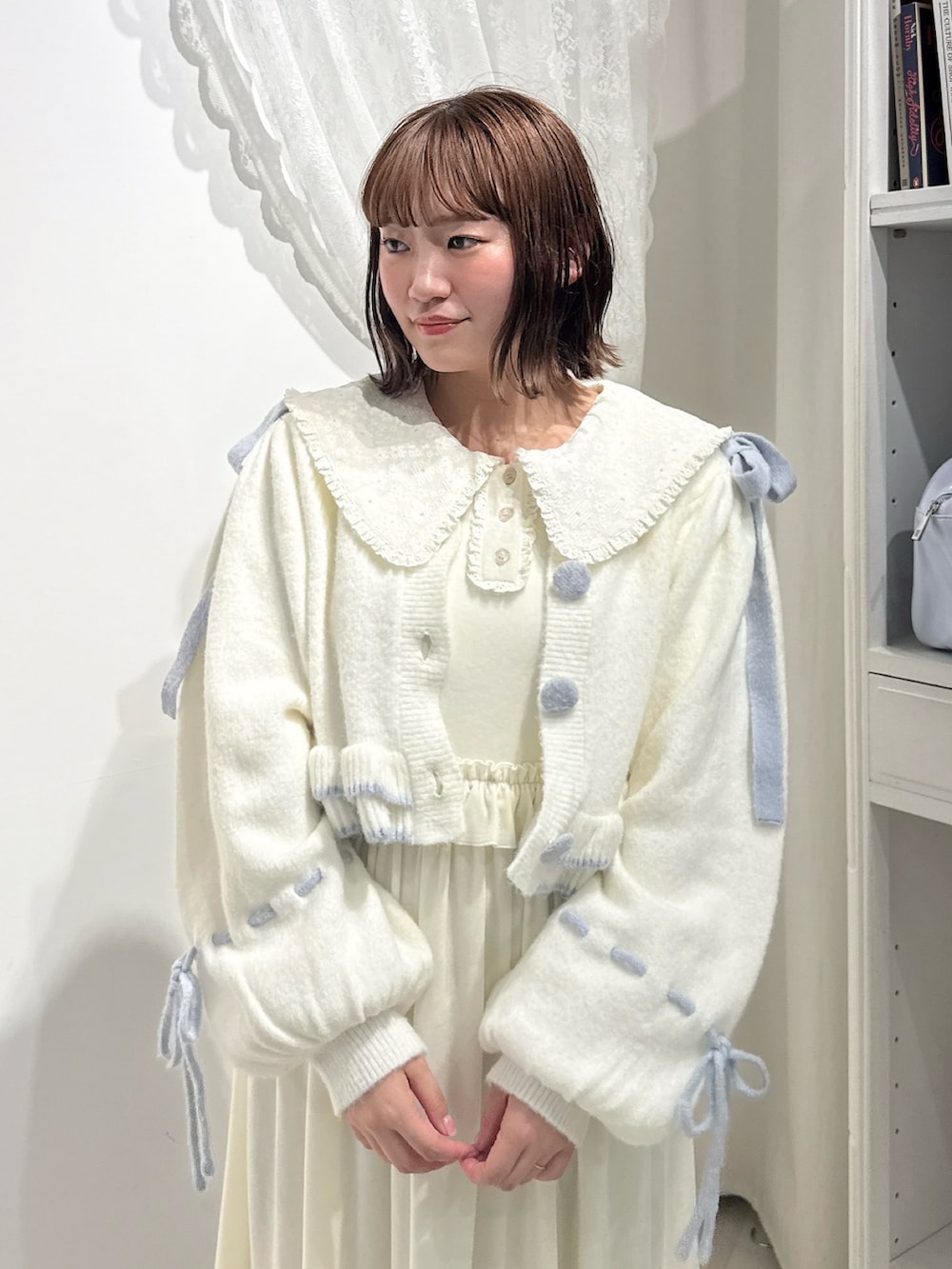 ホワイト系のワンピース、ホワイト系のカーディガン/ボレロ、ブルー系のハンドバッグを着用したレディースの秋コーディネートの6枚目の写真
