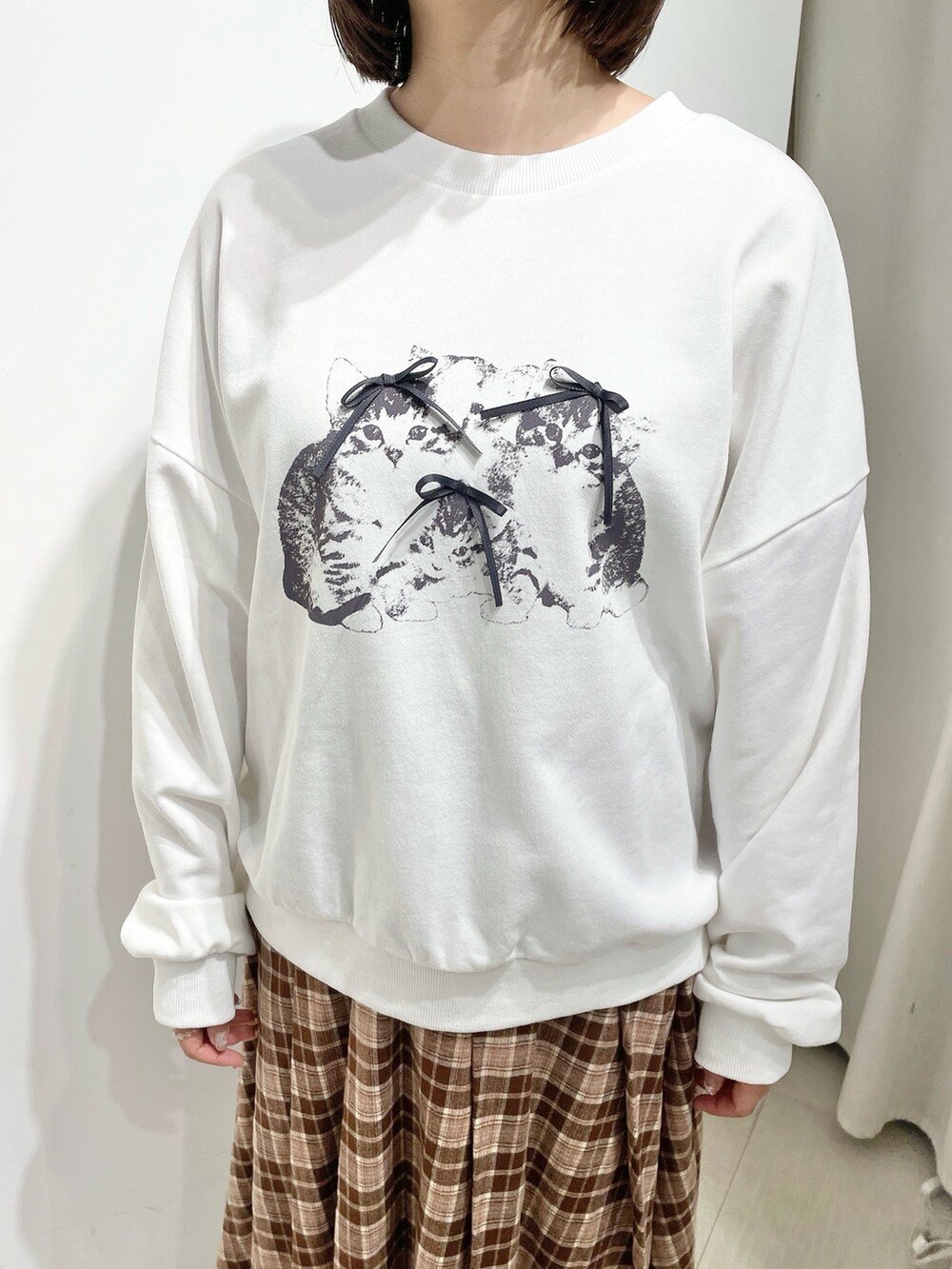 ブラウン系のスカート、ホワイト系のスウェット、ブラウン系のブルゾンを着用したレディースの秋コーディネートの9枚目の写真