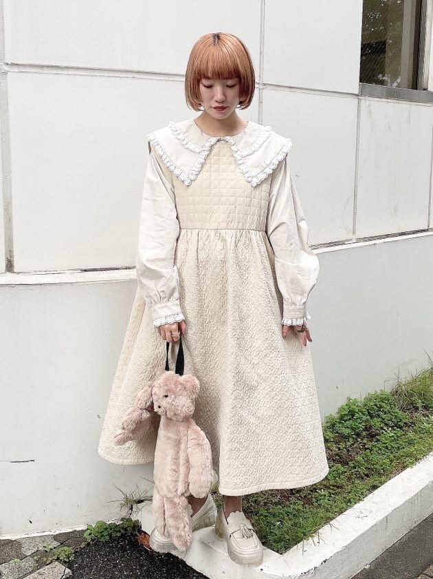 ベージュ系のハンドバッグ、ホワイト系のワンピース、ベージュ系のシャツ/ブラウスを着用したレディースの秋コーディネートの2枚目の写真