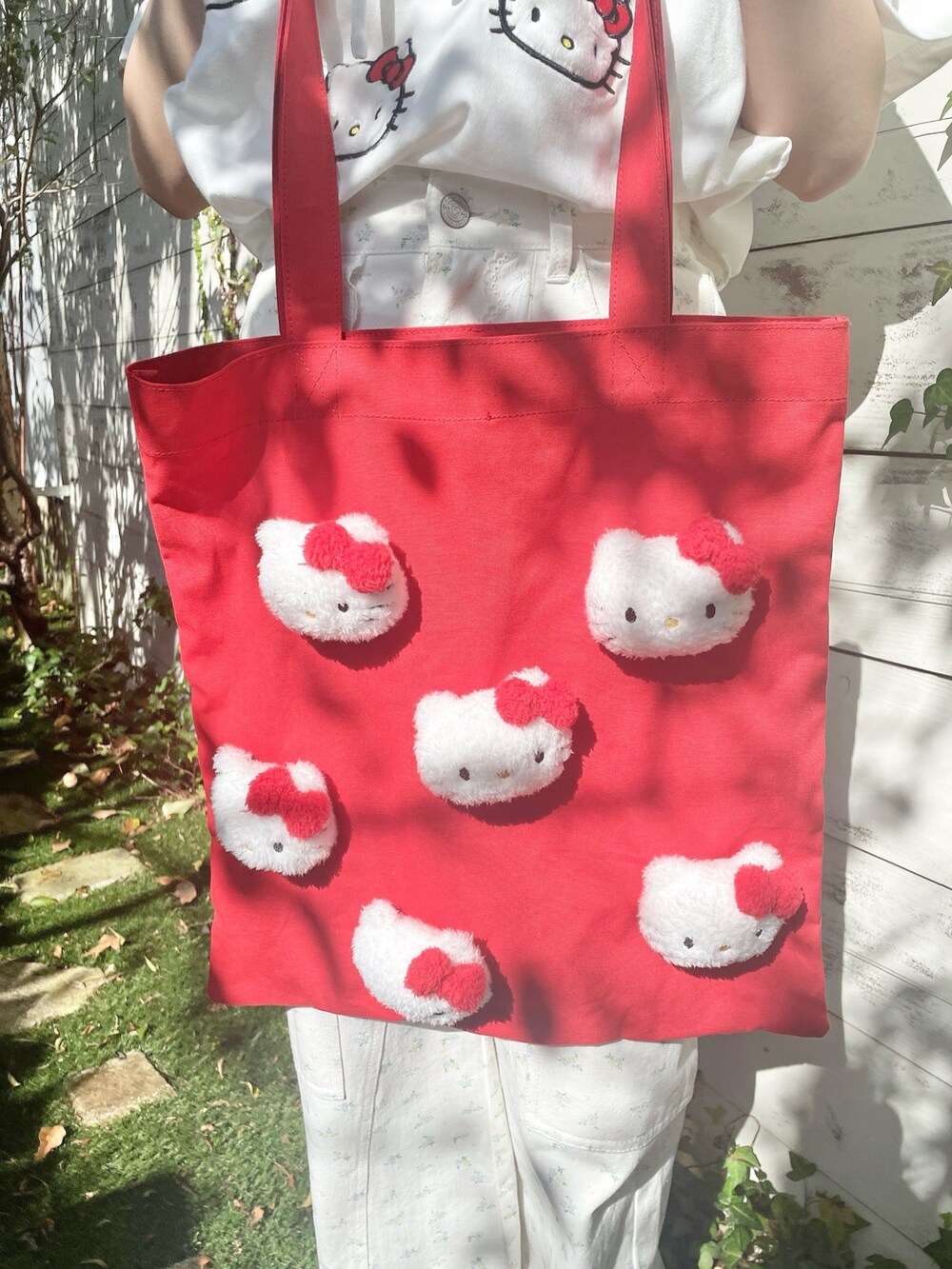 ホワイト系のスニーカー、ホワイト系のカーゴパンツ、レッド系のトートバッグを着用したレディースの春コーディネートの6枚目の写真