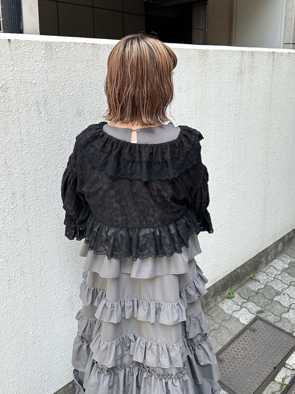 グレー系のワンピース、ブラック系のカーディガン/ボレロ、ピンク系のハンドバッグを着用したレディースの春コーディネートの7枚目の写真
