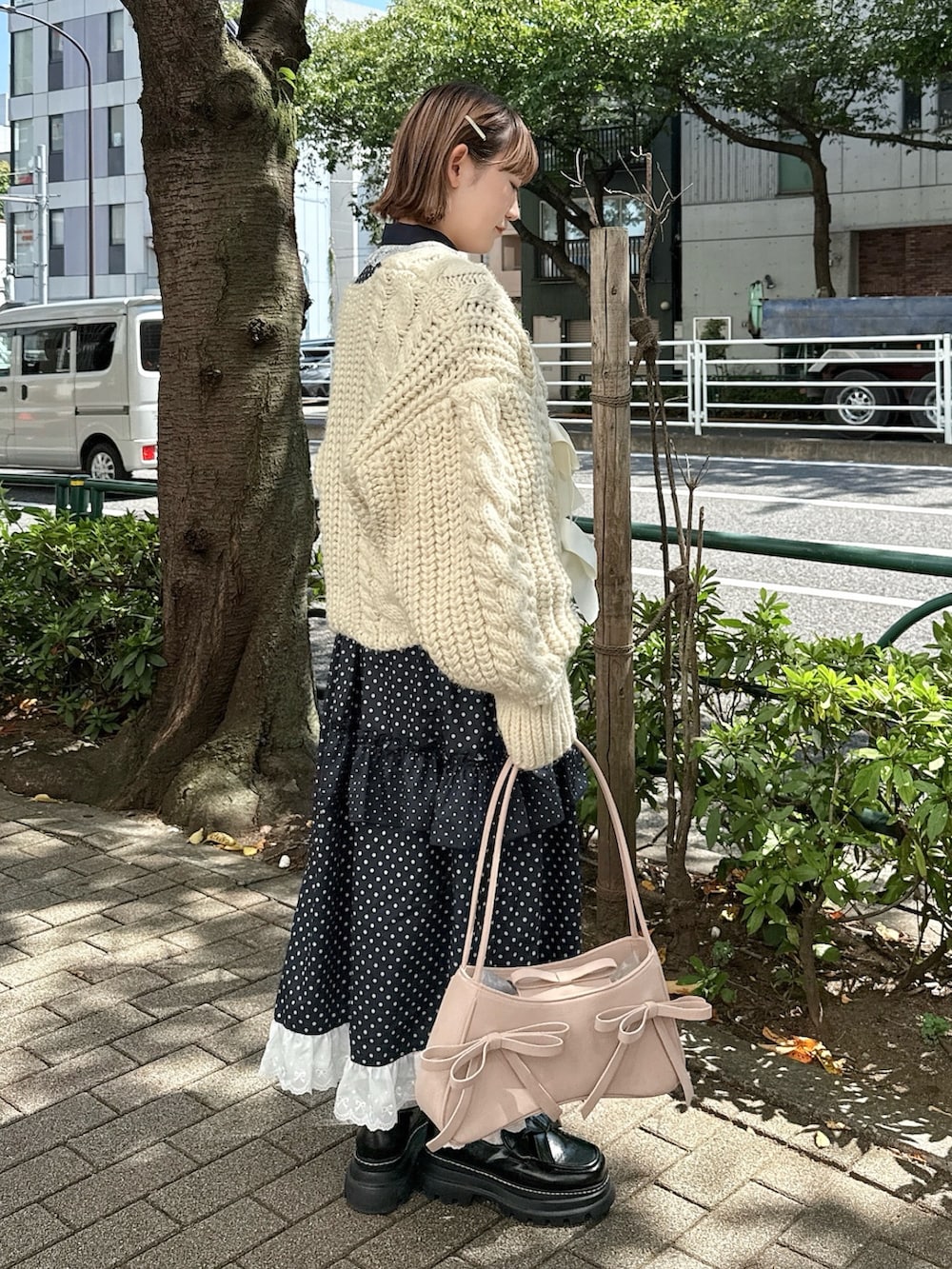 ホワイト系のカーディガン/ボレロ、ピンク系のハンドバッグ、ブラック系のローファーを着用したレディースの秋コーディネートの3枚目の写真