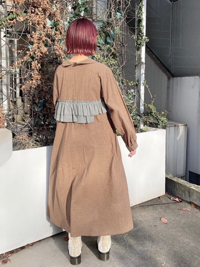 ホワイト系のブーツ、ブラック系のブルゾン、グリーン系のワンピースを着用したレディースの冬コーディネートの2枚目の写真