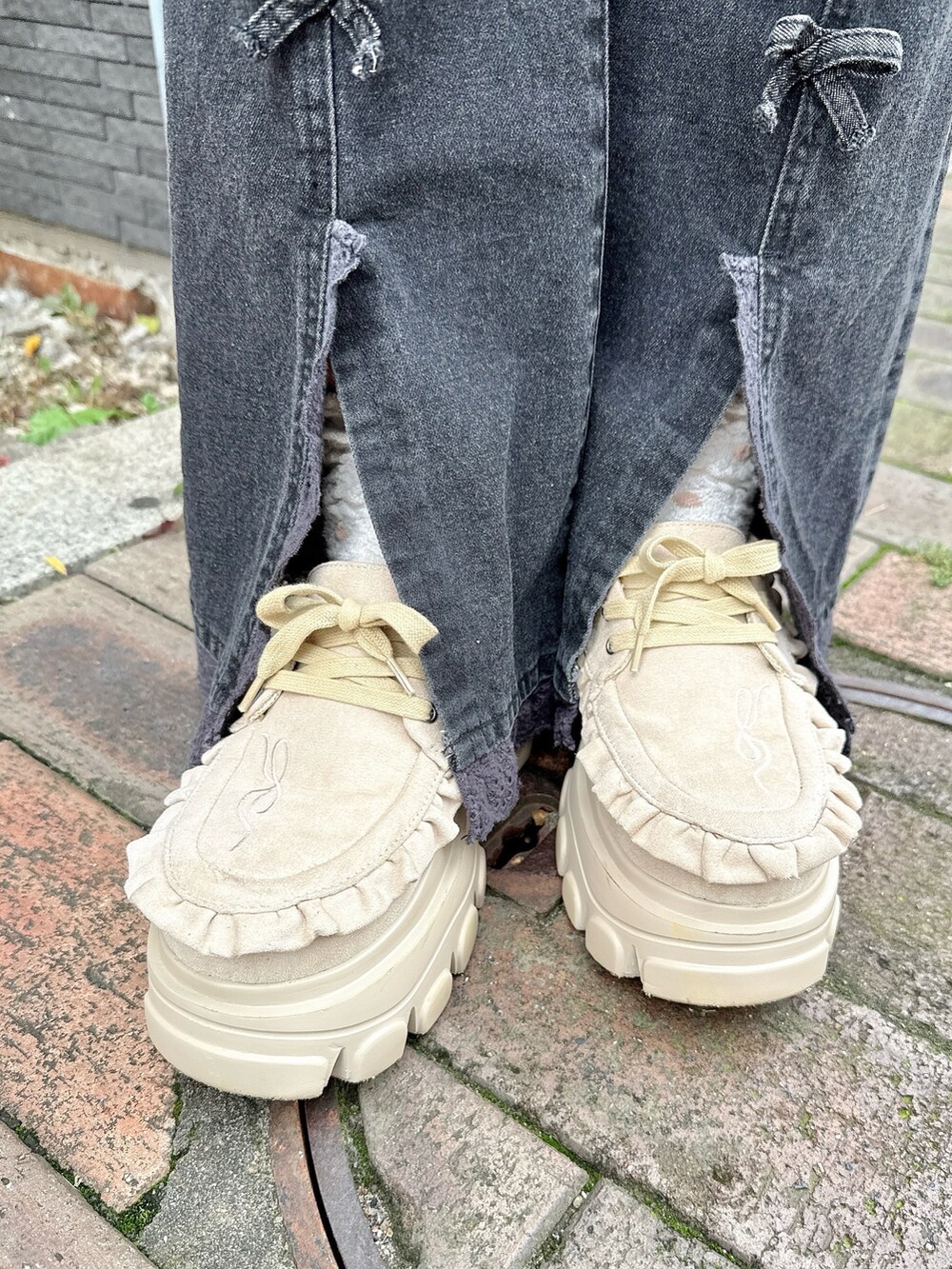 ブラウン系のニット/セーター、ブラック系のハンドバッグ、ブラック系のデニムパンツを着用したレディースの夏コーディネートの7枚目の写真