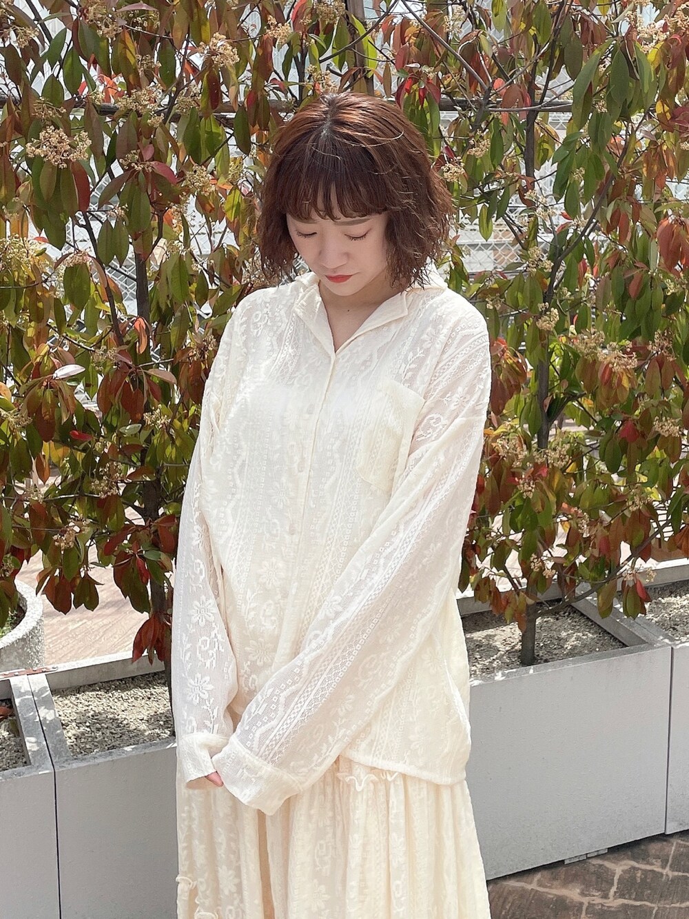 ホワイト系のシャツ/ブラウス、ホワイト系のスカート、シルバー系のパンプスを着用したレディースの春コーディネートの3枚目の写真