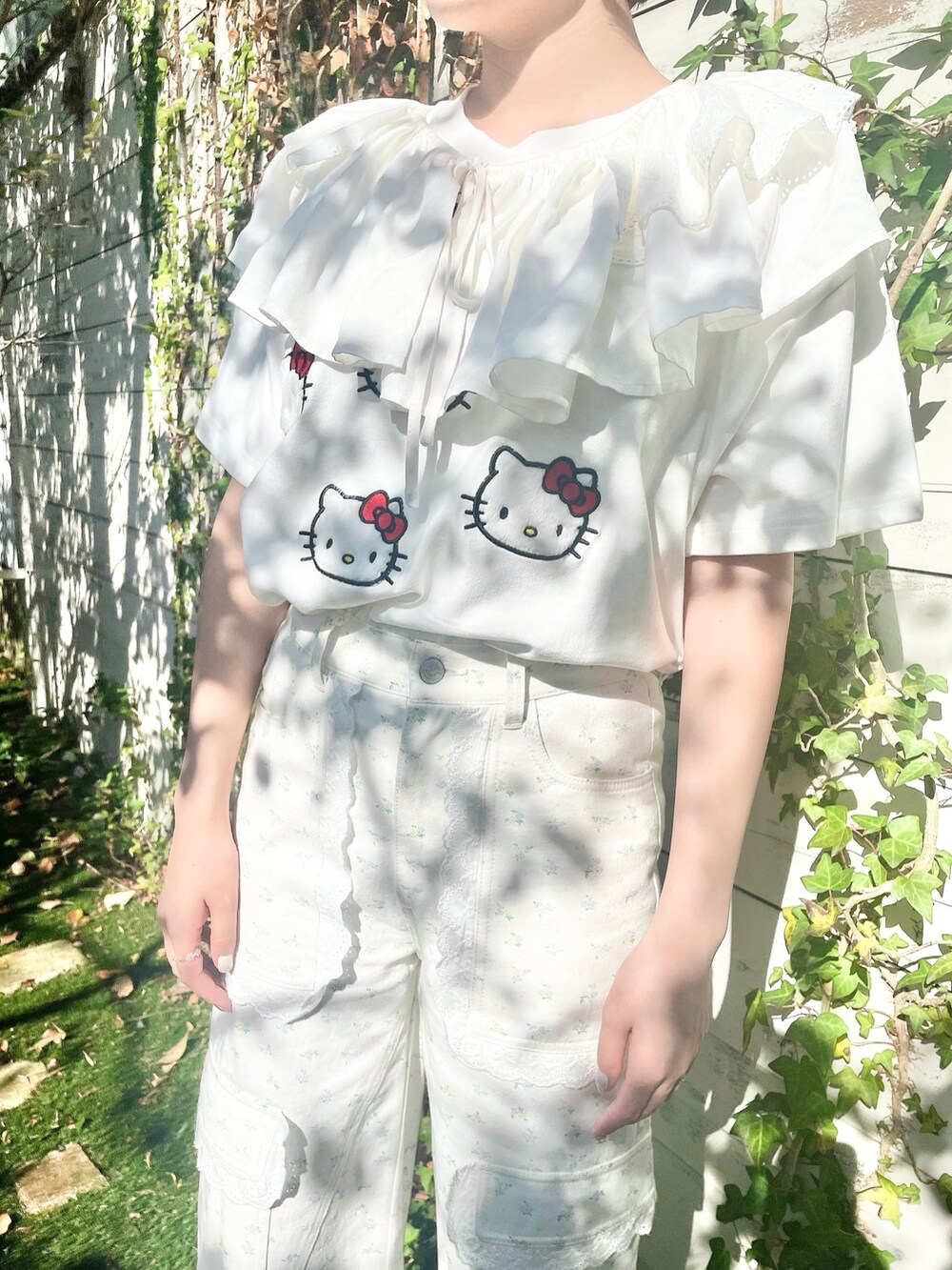 ホワイト系のスニーカー、ホワイト系のカーゴパンツ、レッド系のトートバッグを着用したレディースの春コーディネートの5枚目の写真