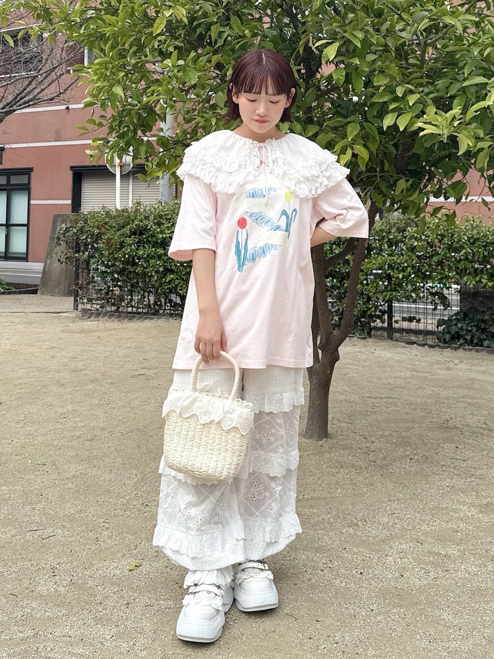 ピンク系のTシャツ/カットソー、ホワイト系のかごバッグ、ホワイト系のスニーカーを着用したレディースの春コーディネートの2枚目の写真