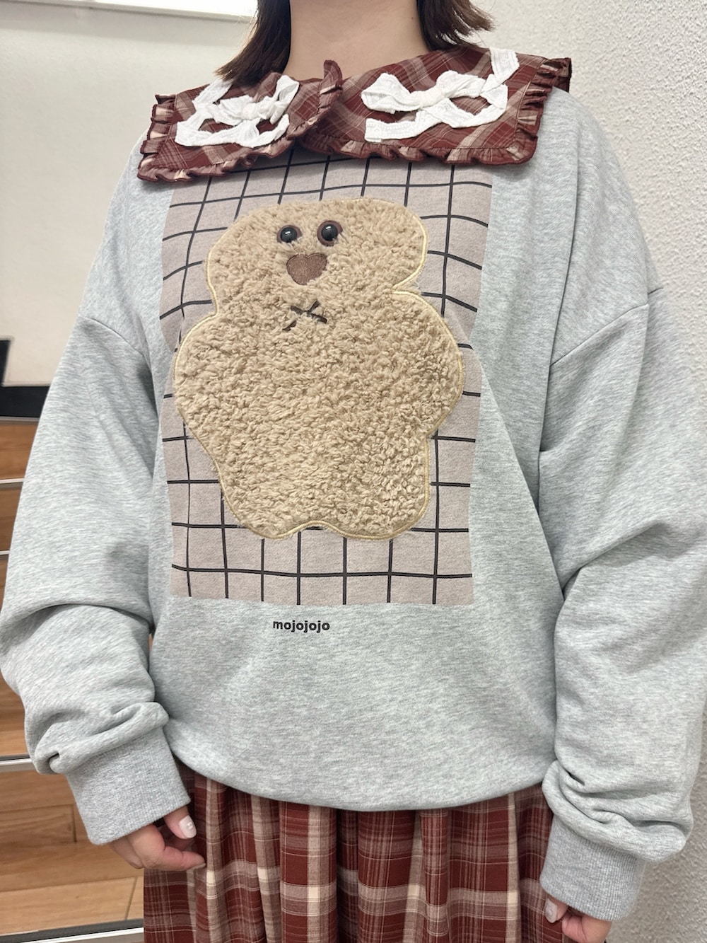 グレー系のスウェット、レッド系のワンピース、ブラウン系のハンドバッグを着用したレディースの秋コーディネートの7枚目の写真