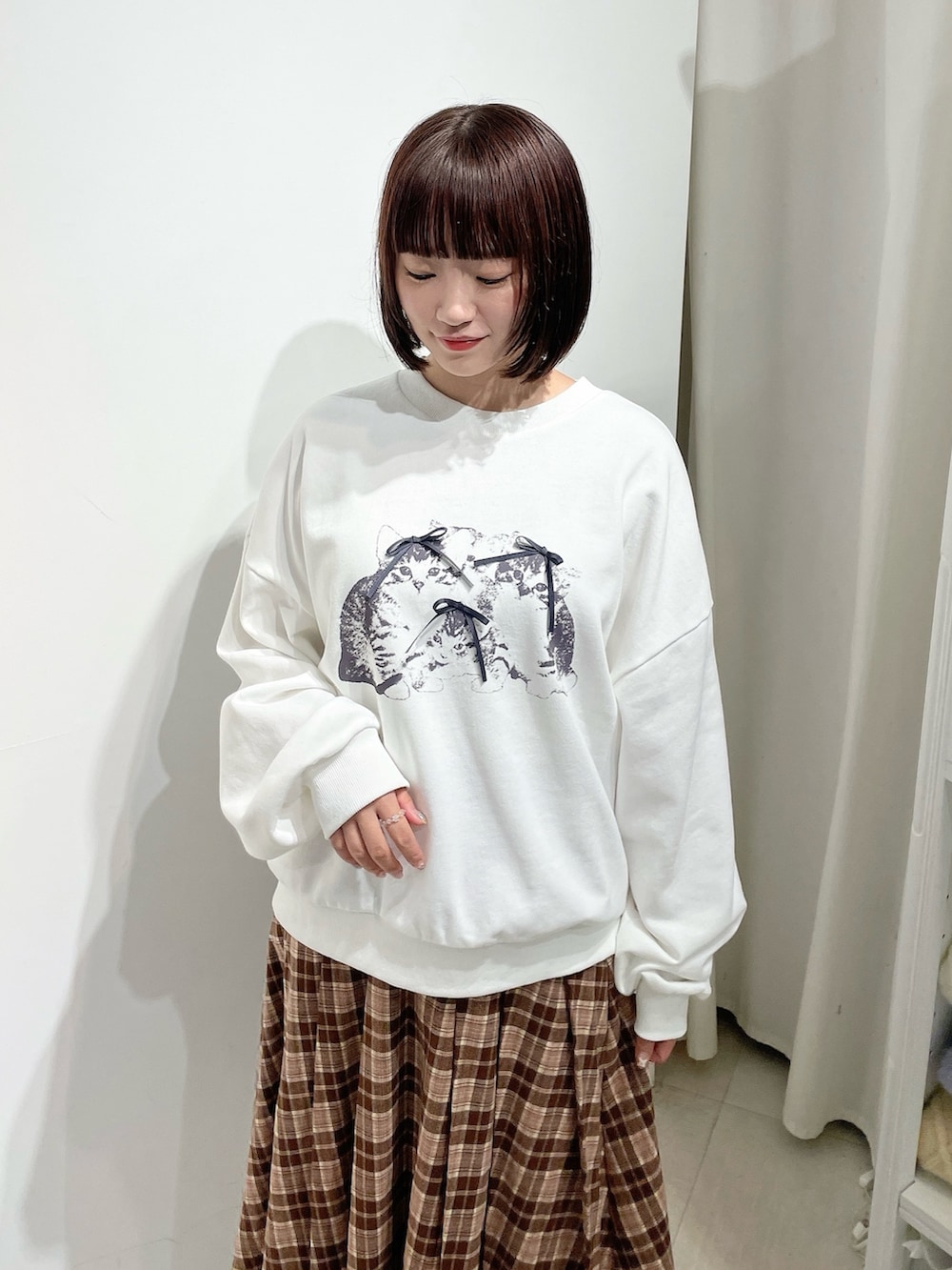 ブラウン系のスカート、ホワイト系のスウェット、ブラウン系のブルゾンを着用したレディースの秋コーディネートの8枚目の写真