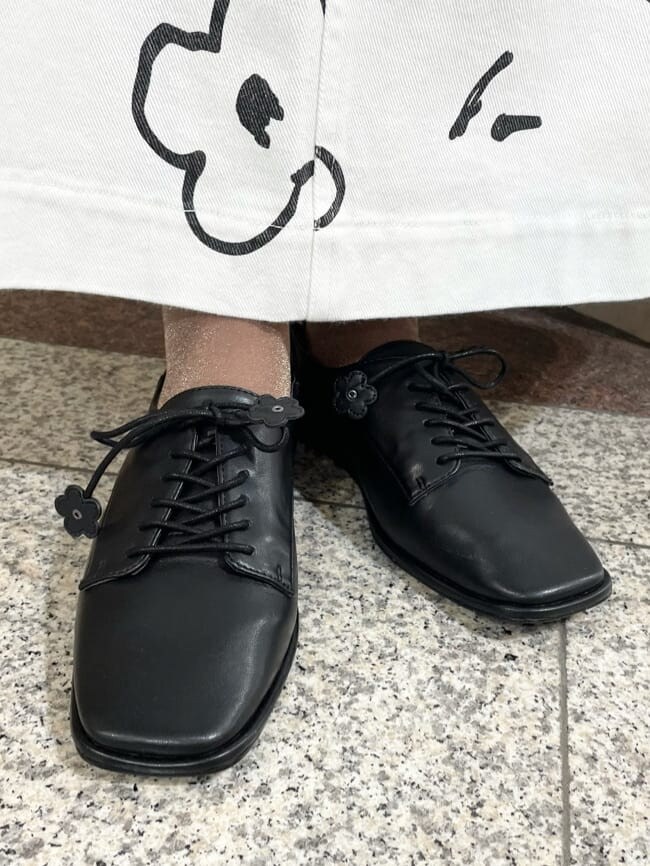 ブラック系のカーディガン/ボレロ、ブラック系のその他シューズ、ピンク系のTシャツ/カットソーを着用したレディースの秋コーディネートの6枚目の写真