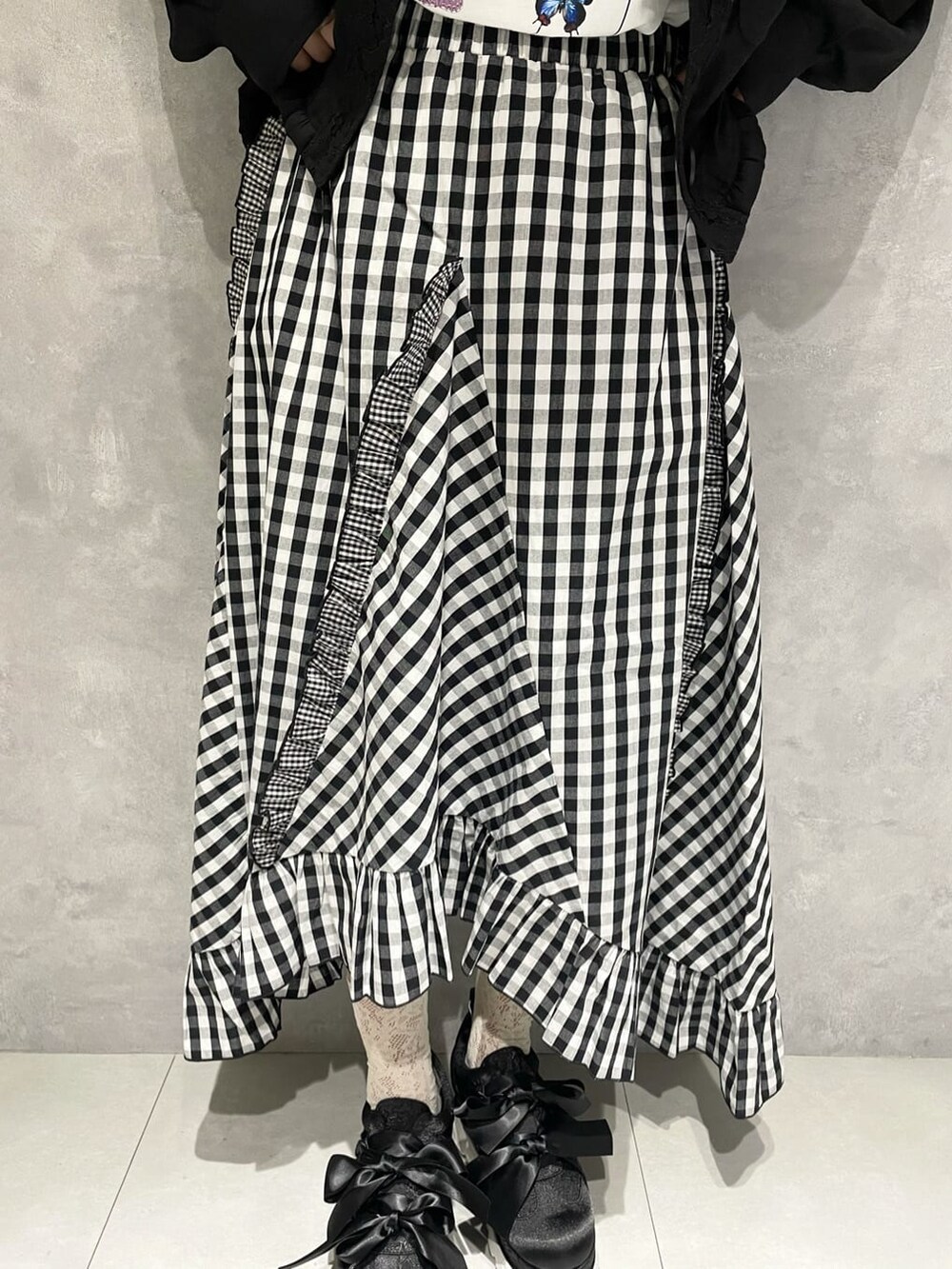 ブラック系のテーラードジャケット、ホワイト系のTシャツ/カットソー、ブラック系のスカートを着用したレディースの秋コーディネートの7枚目の写真