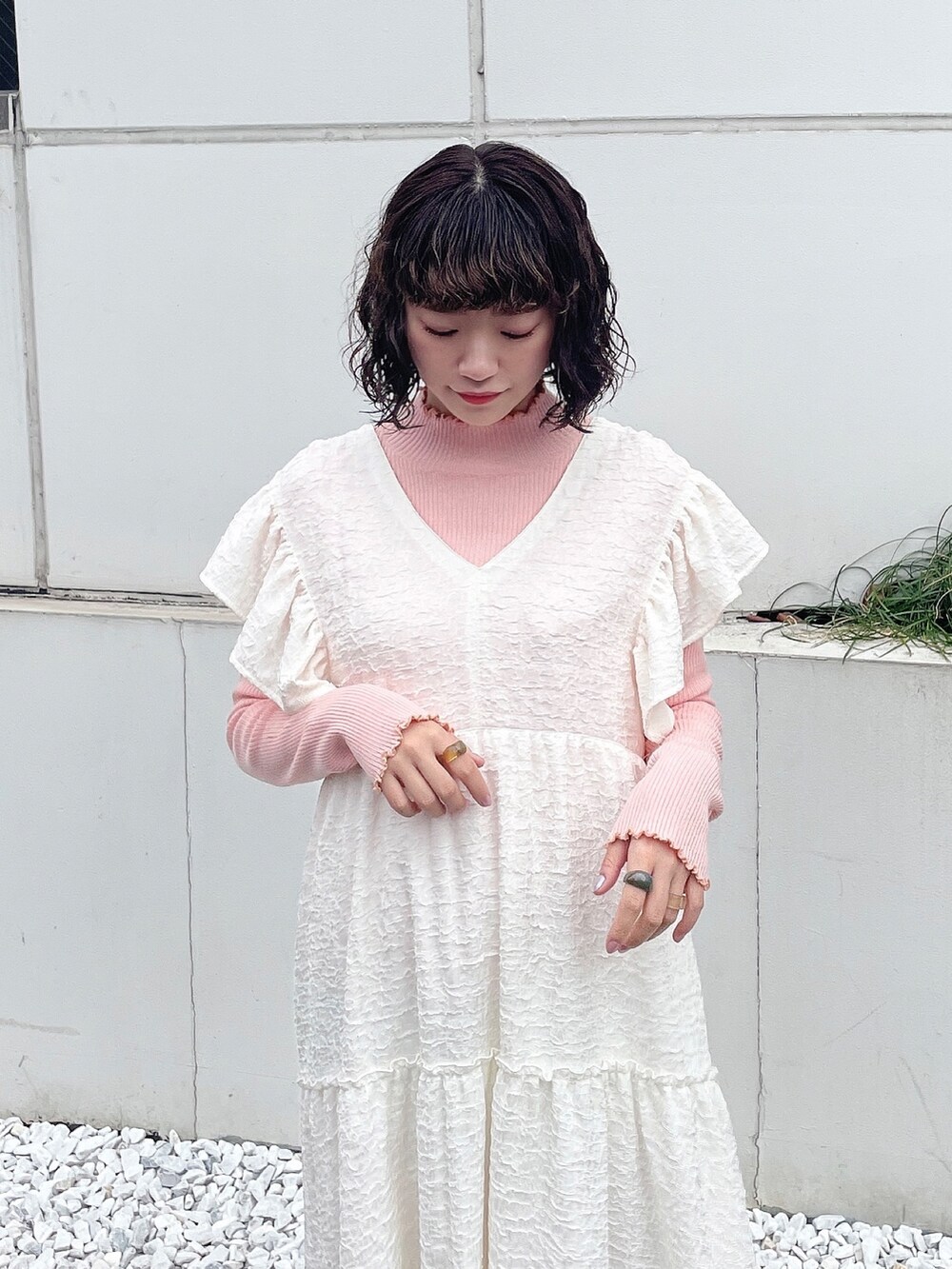 ピンク系のニット/セーター、ホワイト系のワンピース、ベージュ系のブーツを着用したレディースの冬コーディネートの4枚目の写真