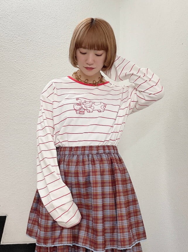 レッド系のTシャツ/カットソー、オレンジ系のスカート、ホワイト系のローファーを着用したレディースの秋コーディネートの4枚目の写真