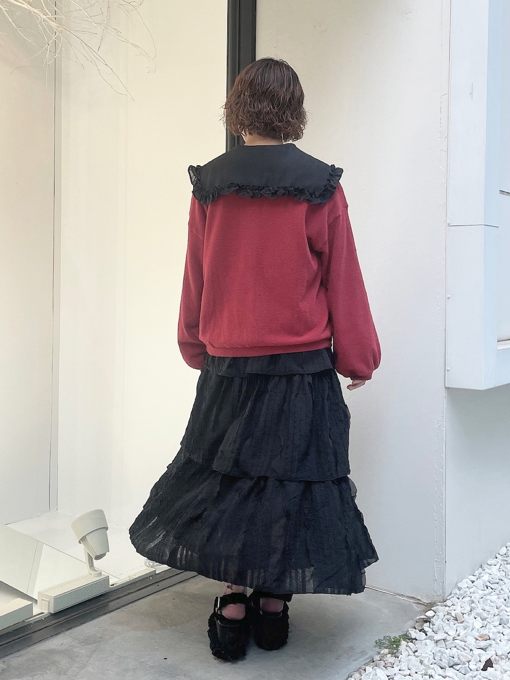 ブラック系のスカート、ブラック系のサンダル、レッド系のカーディガン/ボレロを着用したレディースの夏コーディネートの3枚目の写真