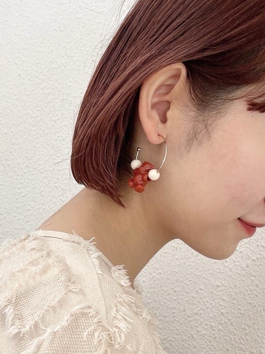 ベージュ系のドレス、グリーン系のハンドバッグ、ベージュ系のブーツを着用したレディースの夏コーディネートの7枚目の写真