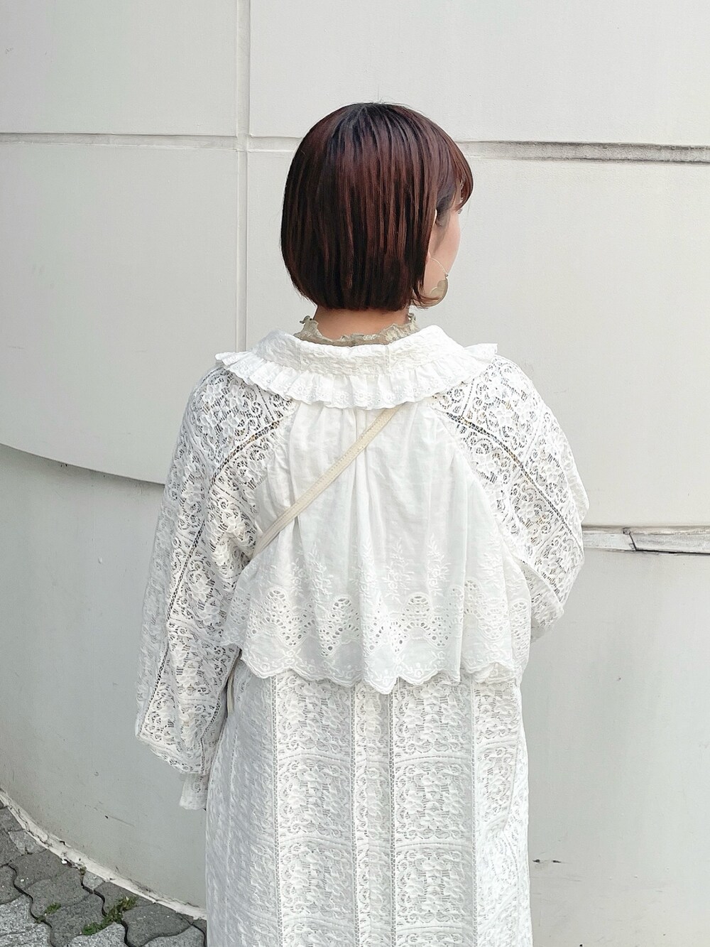 ホワイト系のトレンチコート、グリーン系のTシャツ/カットソー、イエロー系のワンピースを着用したレディースの冬コーディネートの5枚目の写真