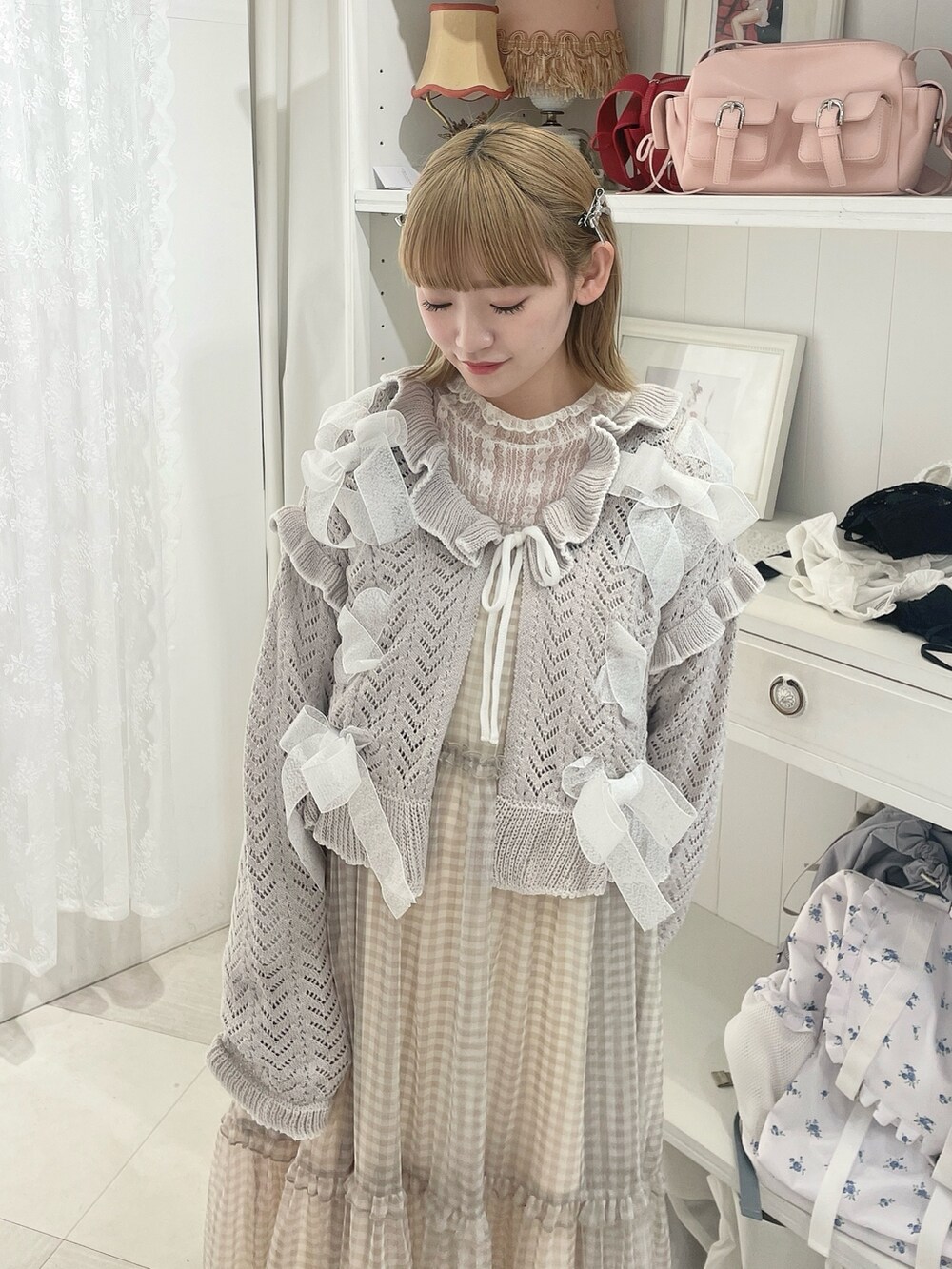 ホワイト系のTシャツ/カットソー、グレー系のカーディガン/ボレロ、グレー系のワンピースを着用したレディースの冬コーディネートの4枚目の写真