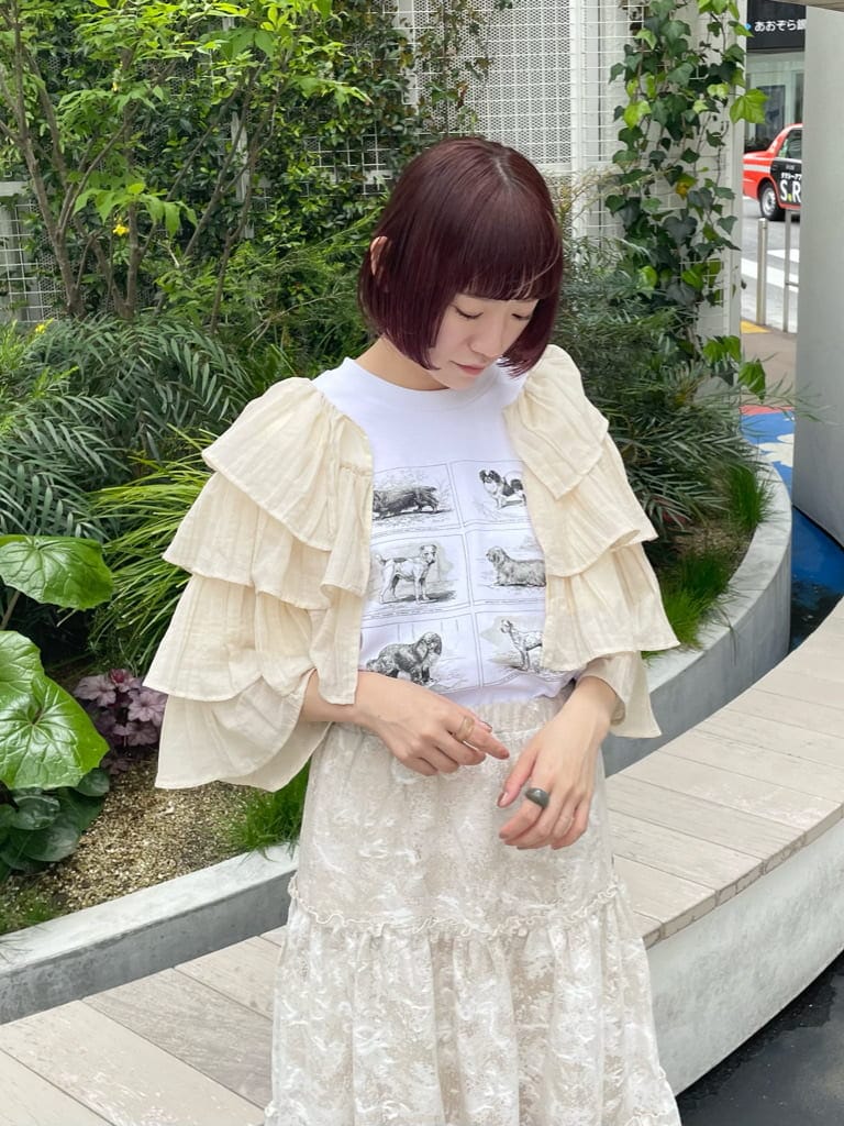 ベージュ系のスカート、ホワイト系のTシャツ/カットソー、ベージュ系のパンプスを着用したレディースの春コーディネートの4枚目の写真