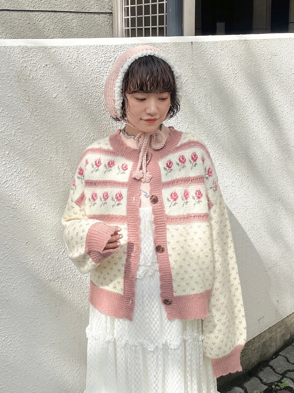 ピンク系のカーディガン/ボレロ、ピンク系のニット/セーター、ホワイト系のワンピースを着用したレディースの秋コーディネートの5枚目の写真