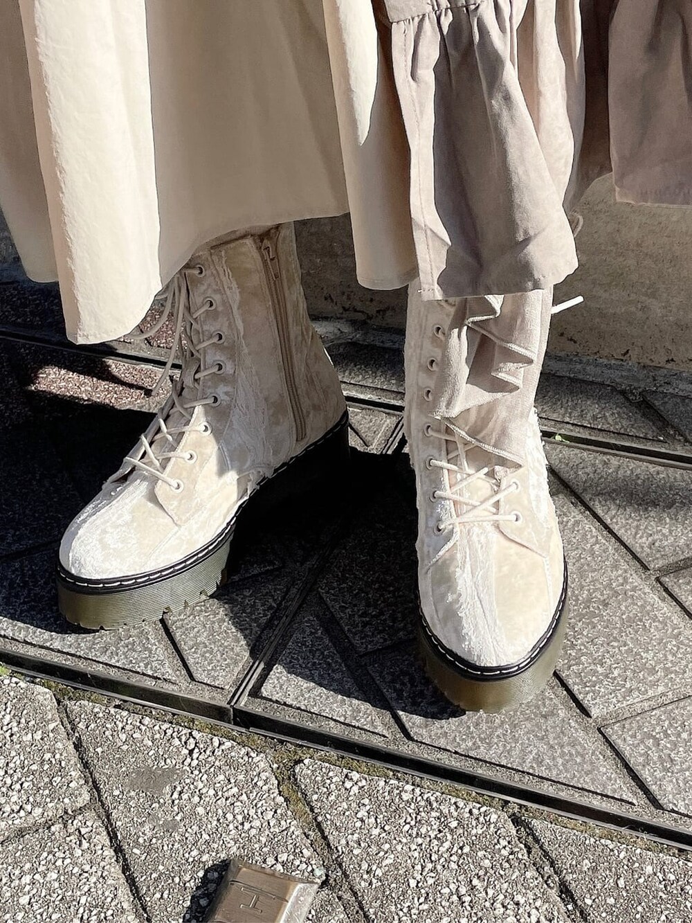 ホワイト系のニット/セーター、ベージュ系のスカート、ホワイト系のブーツを着用したレディースの冬コーディネートの6枚目の写真