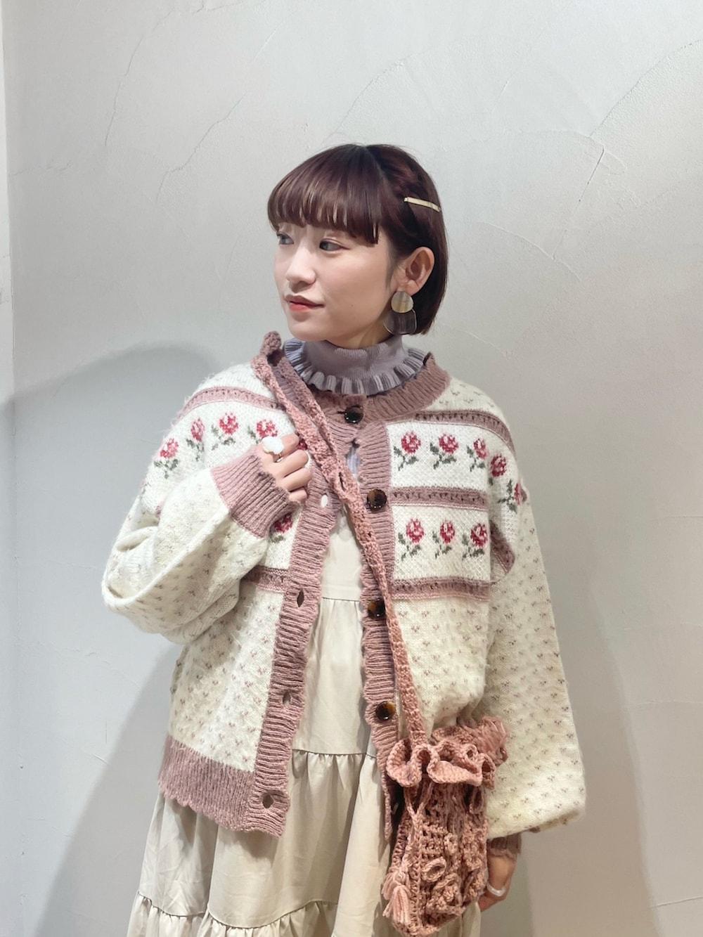 ピンク系のカーディガン/ボレロ、ホワイト系のワンピース、ブラウン系のパンプスを着用したレディースの冬コーディネートの4枚目の写真