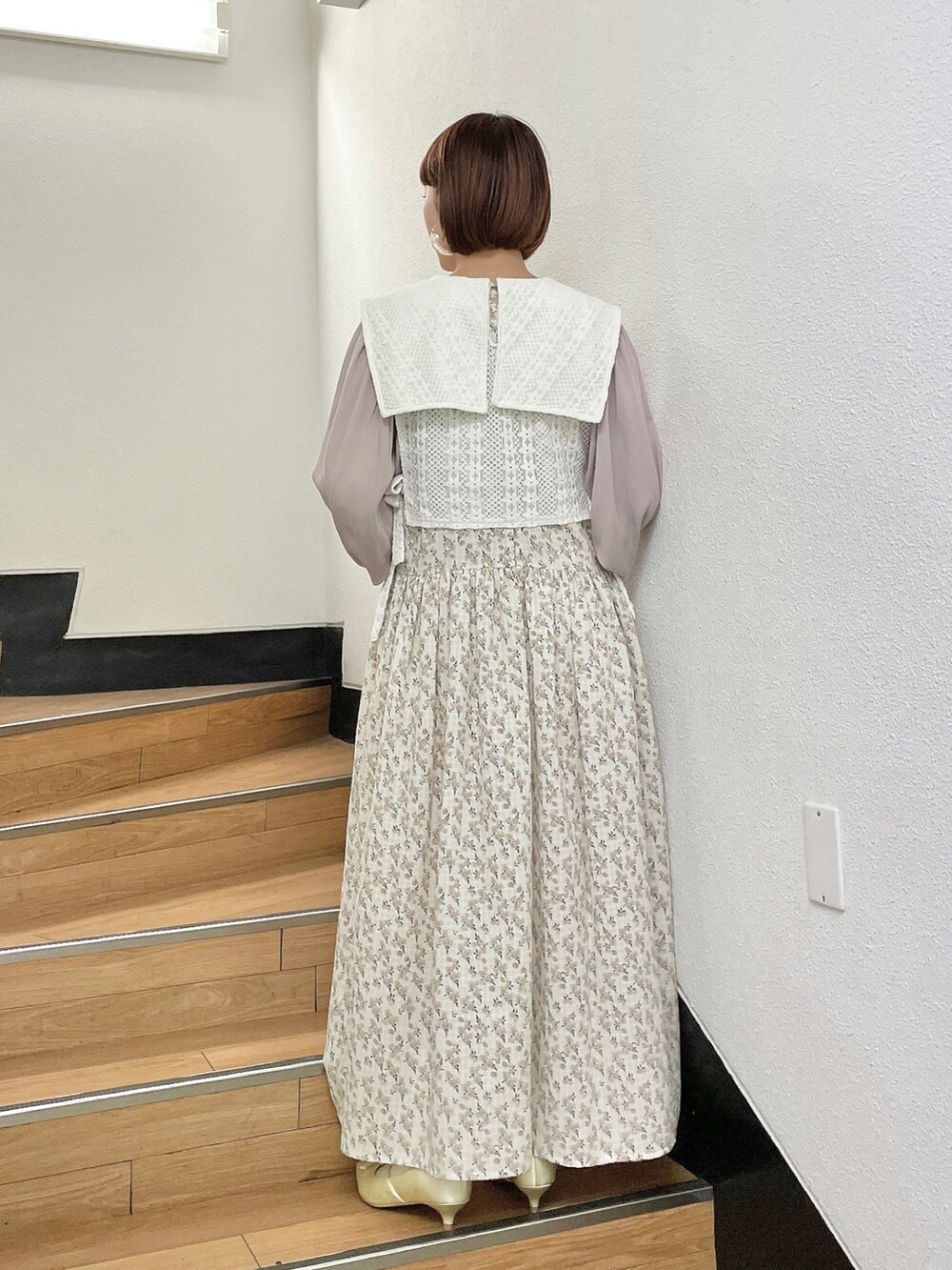 ホワイト系のワンピース、ホワイト系のベスト、ホワイト系のパンプスを着用したレディースの秋コーディネートの3枚目の写真