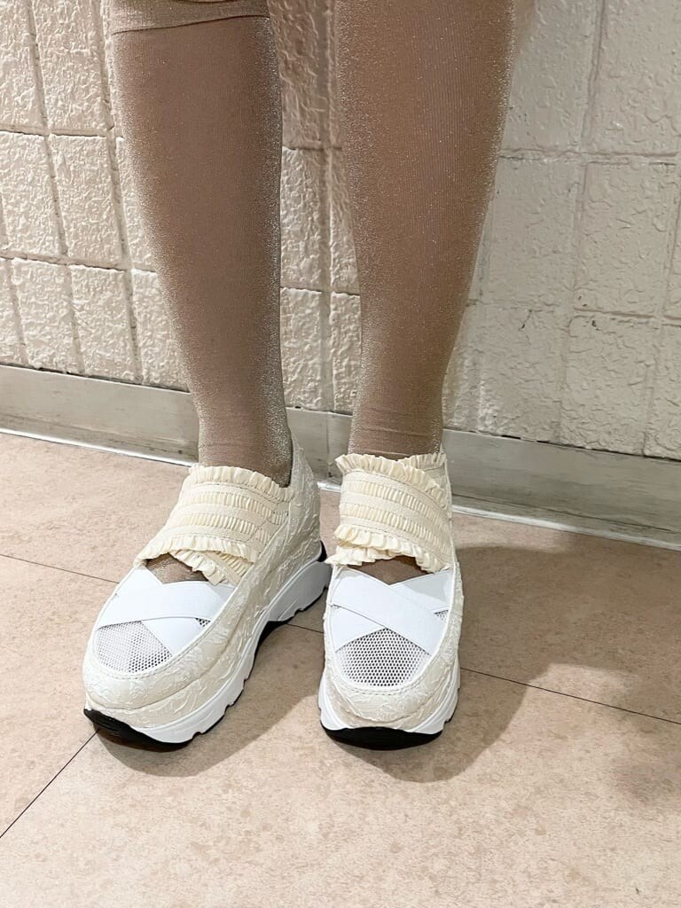 ホワイト系のチュニック、ホワイト系のその他パンツ、ゴールド系のショルダーバッグを着用したレディースの春コーディネートの7枚目の写真