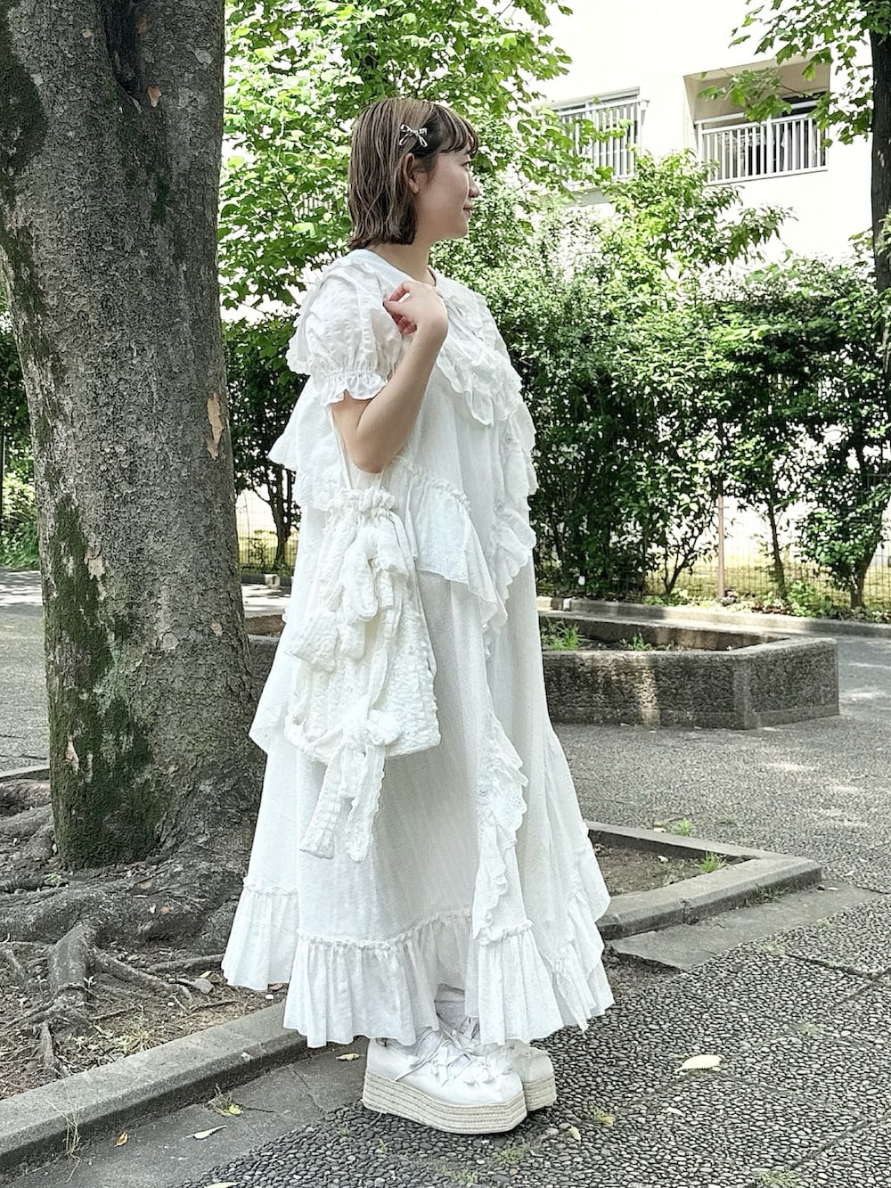 ホワイト系のシャツ/ブラウス、ホワイト系のサンダル、ホワイト系のトートバッグを着用したレディースの春コーディネートの2枚目の写真