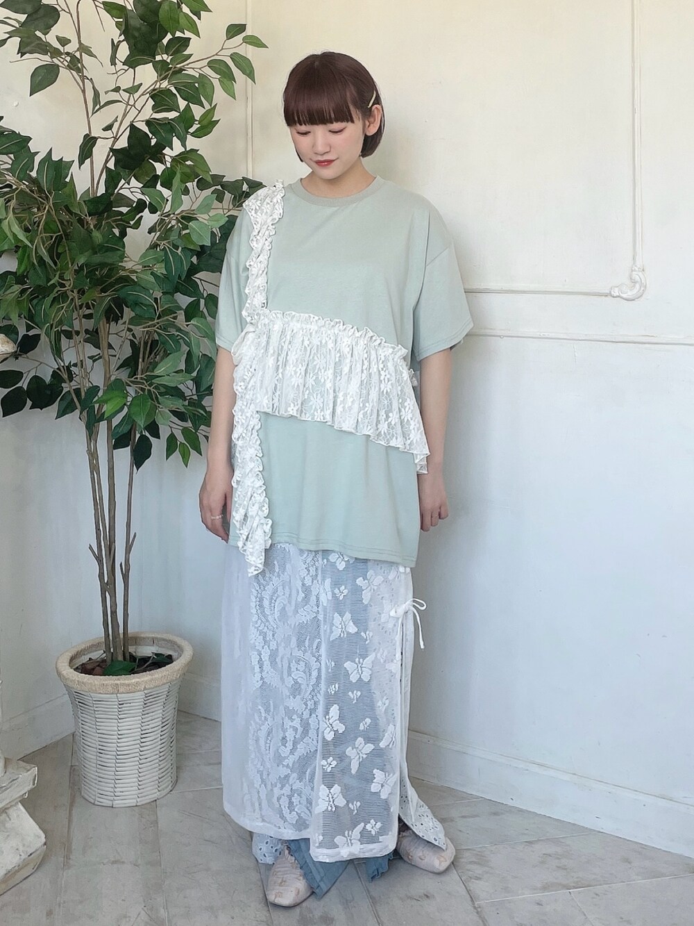 グリーン系のTシャツ/カットソー、ブルー系のデニムパンツ、ホワイト系のスカートを着用したレディースの春コーディネートの2枚目の写真