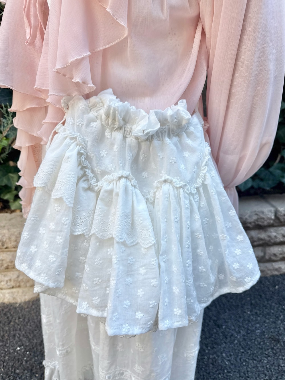 ホワイト系のTシャツ/カットソー、ピンク系のカーディガン/ボレロ、ホワイト系のワンピースを着用したレディースの冬コーディネートの6枚目の写真