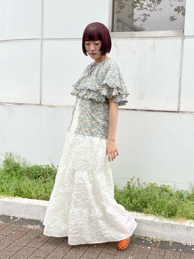 ホワイト系のワンピース、イエロー系のシャツ/ブラウス、オレンジ系のパンプスを着用したレディースの春コーディネートの2枚目の写真