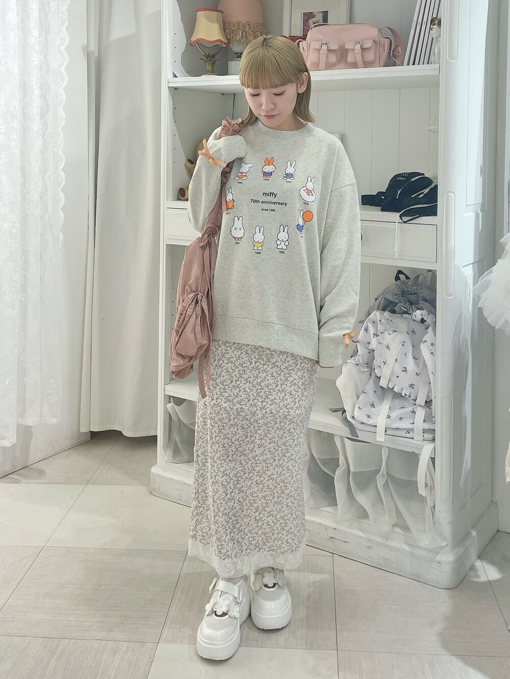 ホワイト系のスカート、グレー系のスウェット、ホワイト系のスニーカーを着用したレディースの冬コーディネートの2枚目の写真