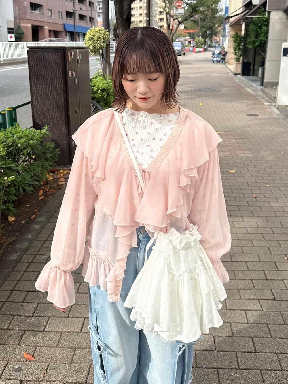 ピンク系のカーディガン/ボレロ、ピンク系のTシャツ/カットソー、ホワイト系のショルダーバッグを着用したレディースの秋コーディネートの6枚目の写真