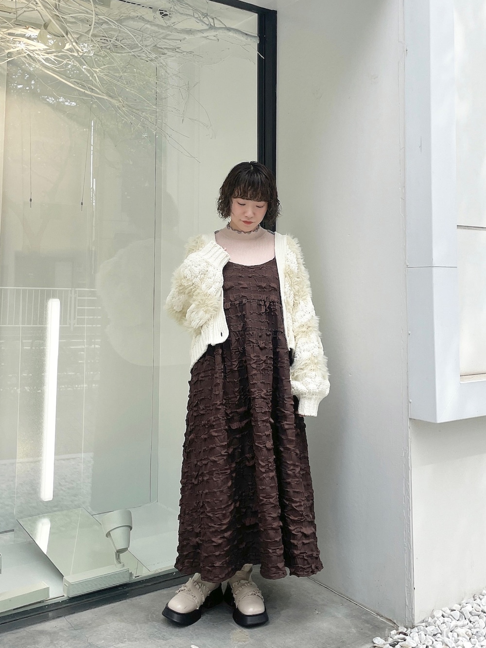 ピンク系のニット/セーター、ホワイト系のカーディガン/ボレロ、ブラウン系のワンピースを着用したレディースの秋コーディネートの2枚目の写真