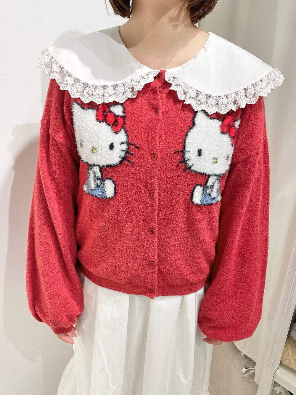 ホワイト系のワンピース、レッド系のカーディガン/ボレロ、ホワイト系のローファーを着用したレディースの秋コーディネートの6枚目の写真