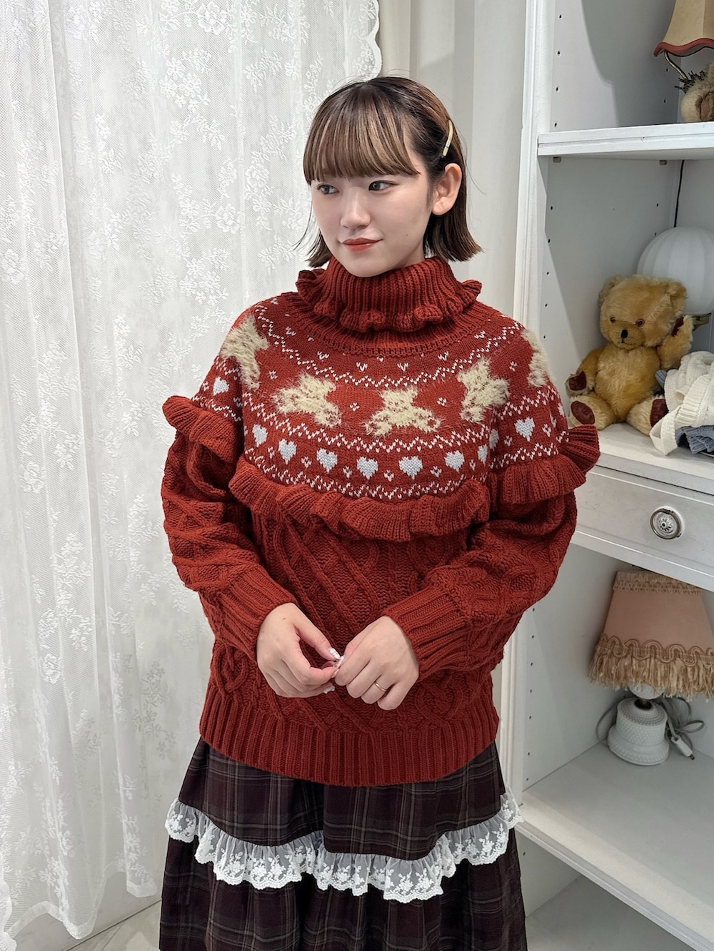 レッド系のニット/セーター、ブラウン系のスカート、レッド系のローファーを着用したレディースの秋コーディネートの4枚目の写真