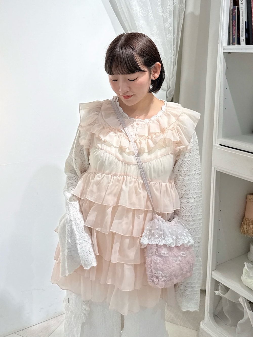 ピンク系のシャツ/ブラウス、ホワイト系のニット/セーター、ピンク系のハンドバッグを着用したレディースの夏コーディネートの4枚目の写真