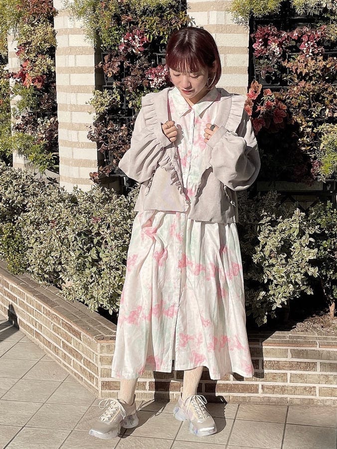 ベージュ系のその他アウター、ピンク系のワンピース、ホワイト系のスニーカーを着用したレディースの冬コーディネートの2枚目の写真