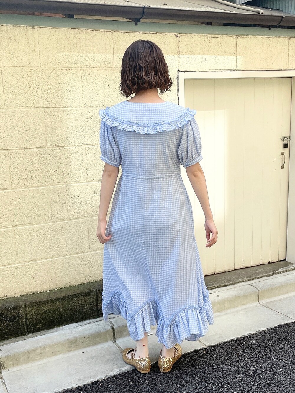 ホワイト系のカーディガン/ボレロ、ブルー系のワンピース、ゴールド系のパンプスを着用したレディースの春コーディネートの5枚目の写真