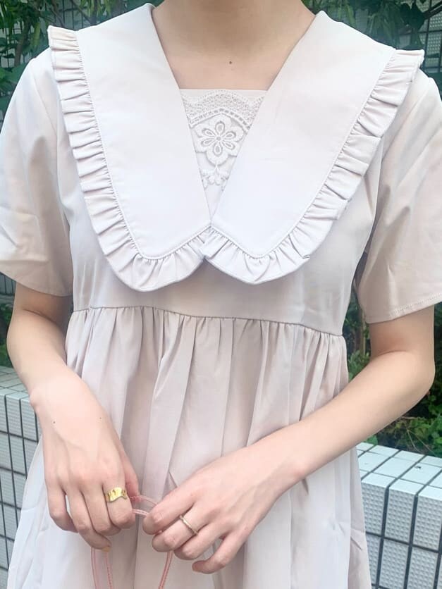 ピンク系のハンドバッグ、ベージュ系のワンピース、ピンク系のスニーカーを着用したレディースの夏コーディネートの4枚目の写真