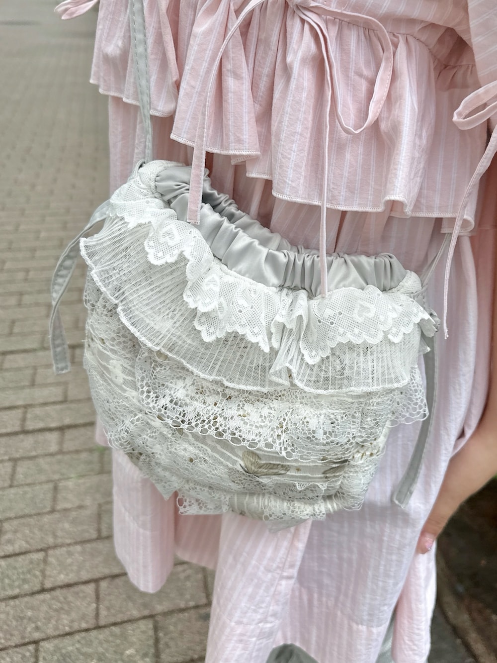 ブルー系のショルダーバッグ、ピンク系のワンピース、グレー系のその他パンツを着用したレディースの春コーディネートの8枚目の写真