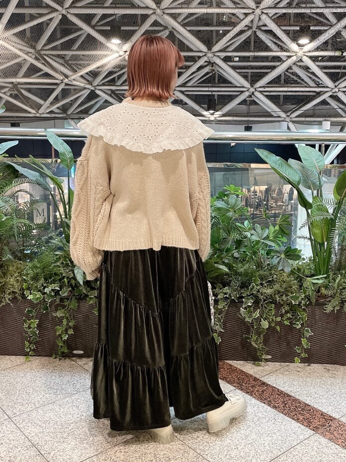 ベージュ系のスカート、ホワイト系のローファー、グリーン系のショルダーバッグを着用したレディースの冬コーディネートの3枚目の写真