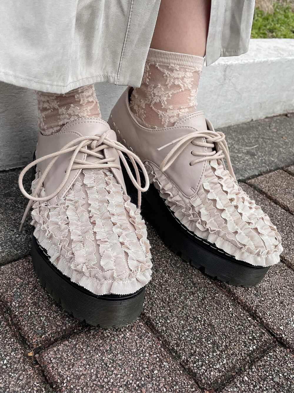 ベージュ系のワンピース、ピンク系のその他シューズ、ブラック系のカーディガン/ボレロを着用したレディースの冬コーディネートの4枚目の写真