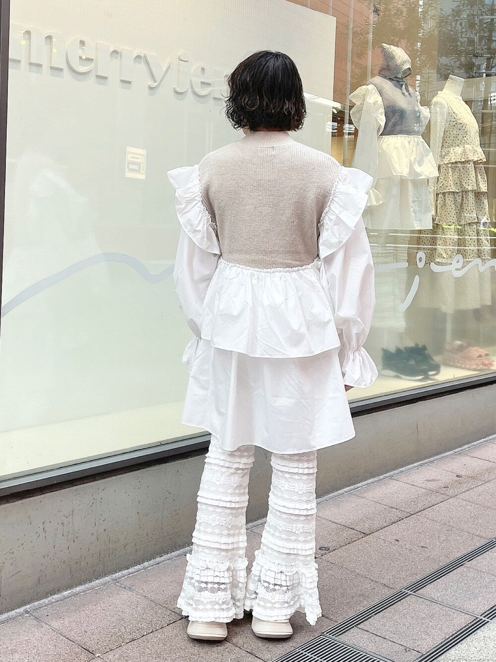 ベージュ系のワンピース、ホワイト系のスニーカー、ホワイト系のスウェットパンツを着用したレディースの秋コーディネートの3枚目の写真