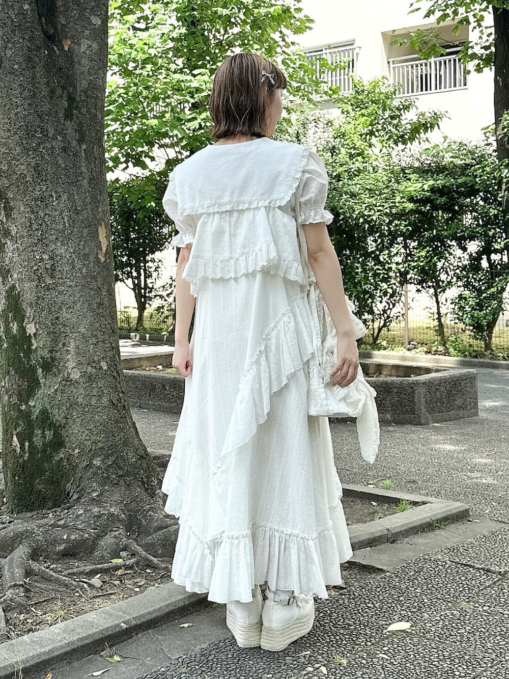 ホワイト系のシャツ/ブラウス、ホワイト系のサンダル、ホワイト系のトートバッグを着用したレディースの春コーディネートの3枚目の写真