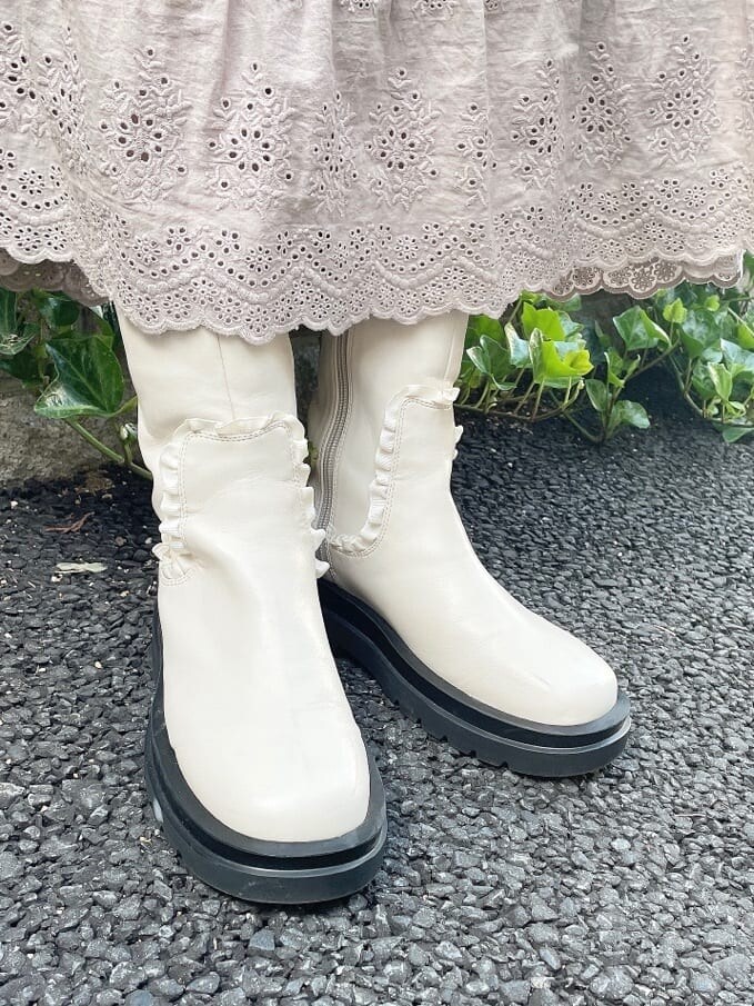 ホワイト系のブーツ、ブルー系のニット/セーター、ホワイト系のナイロンジャケットを着用したレディースの秋コーディネートの7枚目の写真