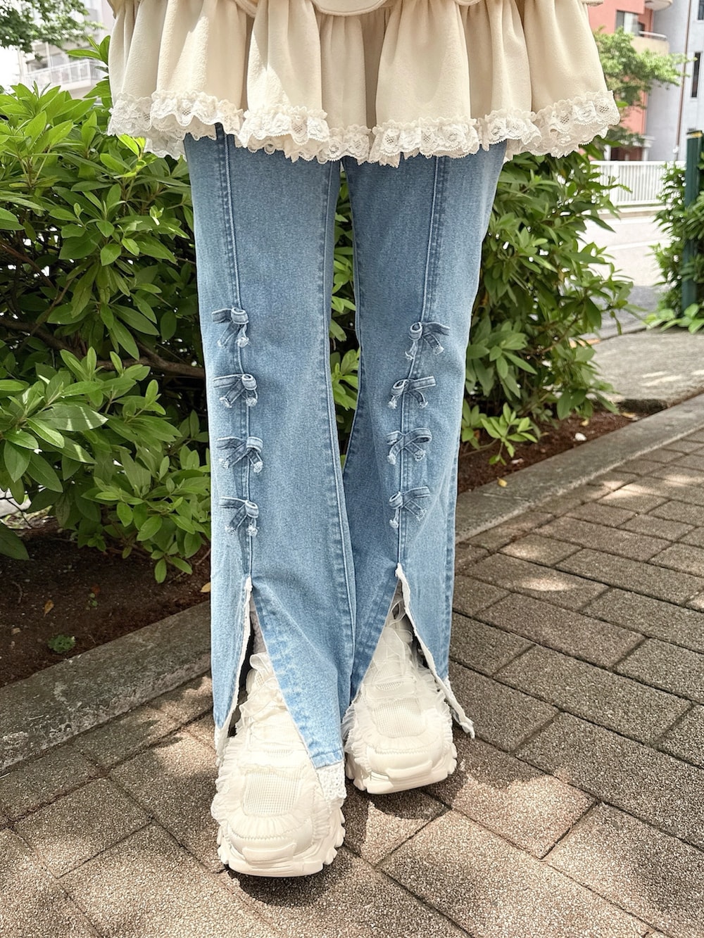 ブルー系のデニムパンツ、ホワイト系のスカート、ホワイト系のパーカーを着用したレディースの春コーディネートの7枚目の写真