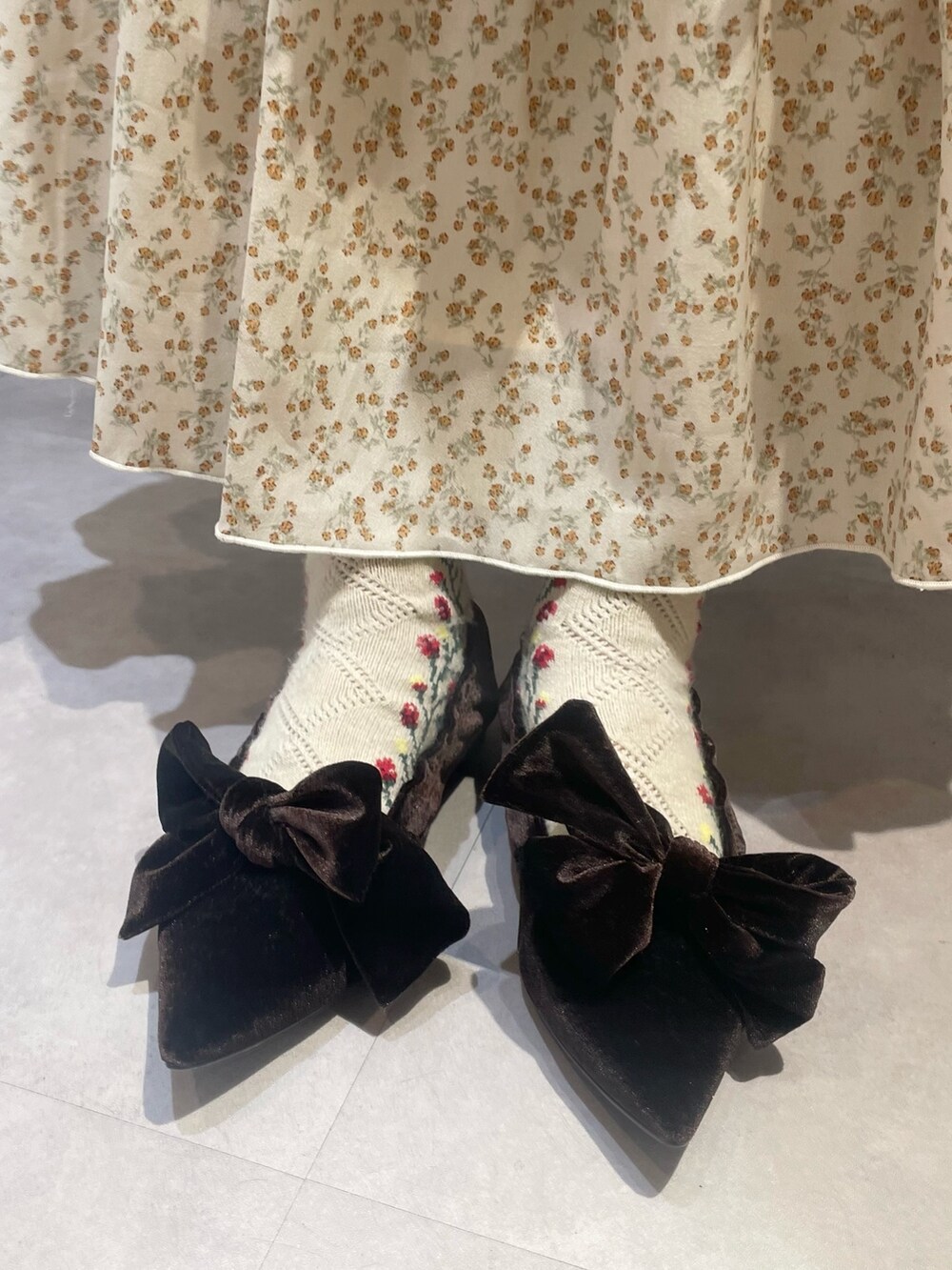 ホワイト系のニット/セーター、ブラウン系のパンプス、ホワイト系のスカートを着用したレディースの冬コーディネートの5枚目の写真