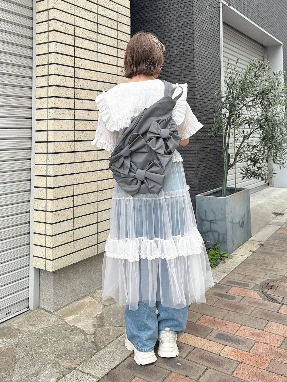 グレー系のショルダーバッグ、ホワイト系のシャツ/ブラウス、ピンク系のスカートを着用したレディースの春コーディネートの3枚目の写真