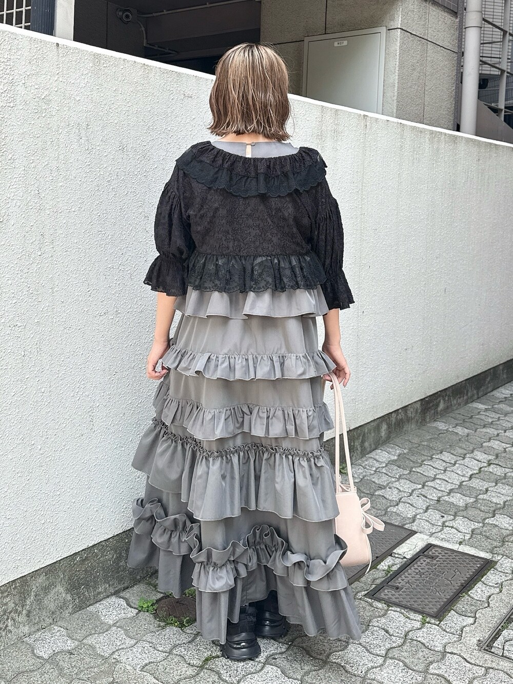 グレー系のワンピース、ブラック系のカーディガン/ボレロ、ピンク系のハンドバッグを着用したレディースの春コーディネートの5枚目の写真